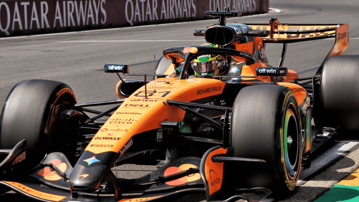 Oscar Piastri en combinaison McLaren orange dans le paddock