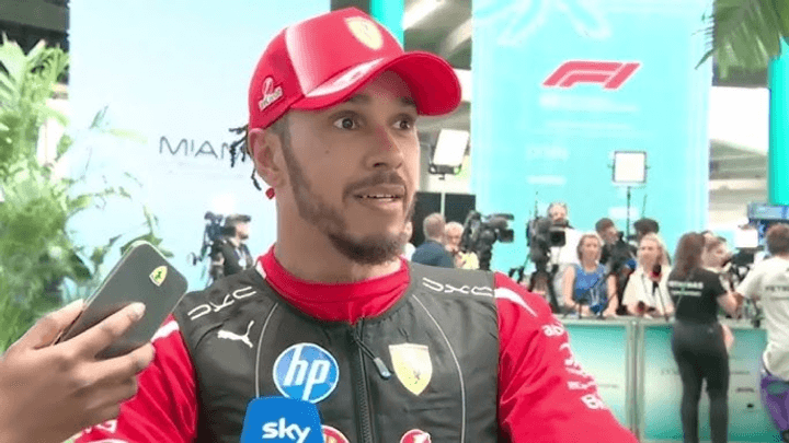 Pilote Ferrari en interview, portant casquette et combinaison rouge lors d'un événement F1