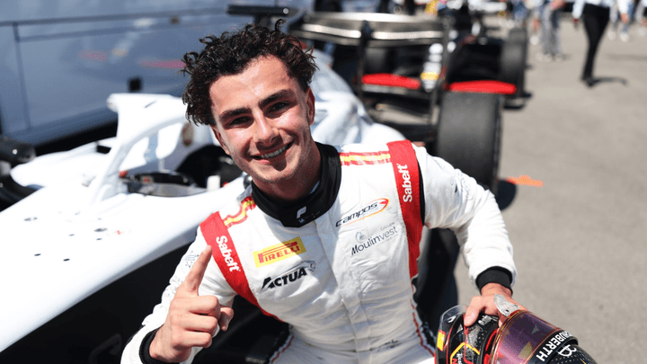 Théophile Naël sourit en combinaison de course devant sa monoplace de Formule 3